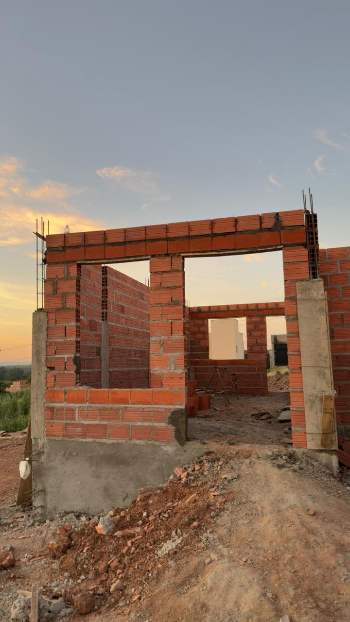 Paredes erguidas com vergas nas janelas, ao pôr do sol