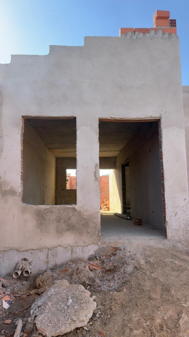 Frente da casa rebocada, com aberturas de porta e janela
